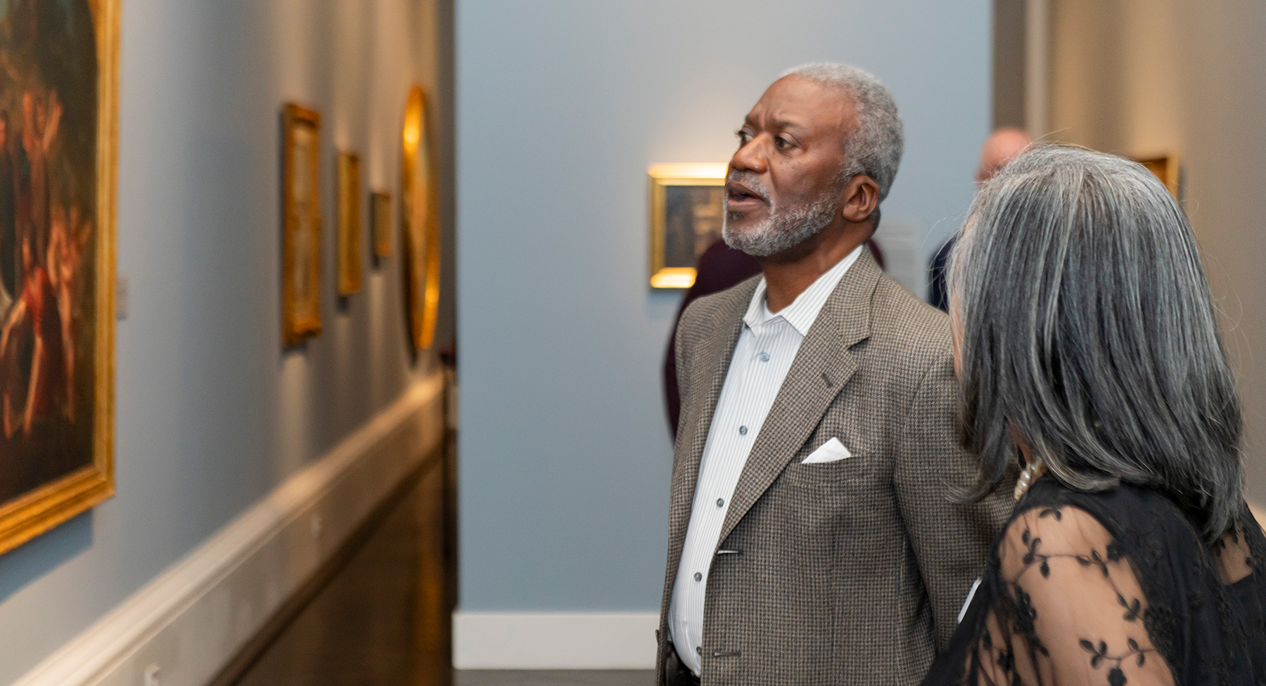 Meadows reception: two people looking at a painting in the galleries